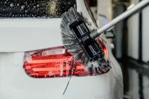 Een borstel gaat over het achterlicht van een auto